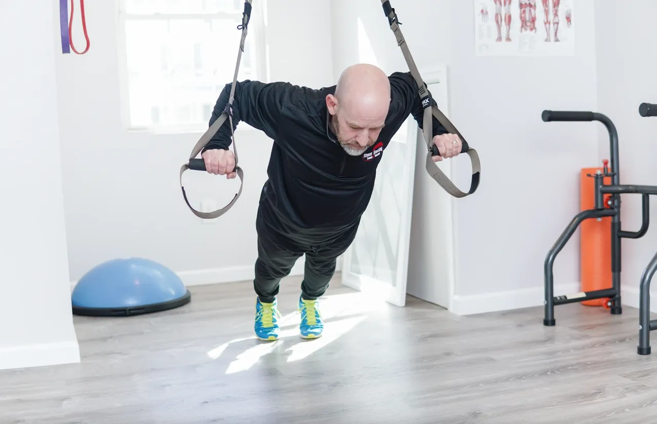 Personal trainer demonstrating TRX push-up