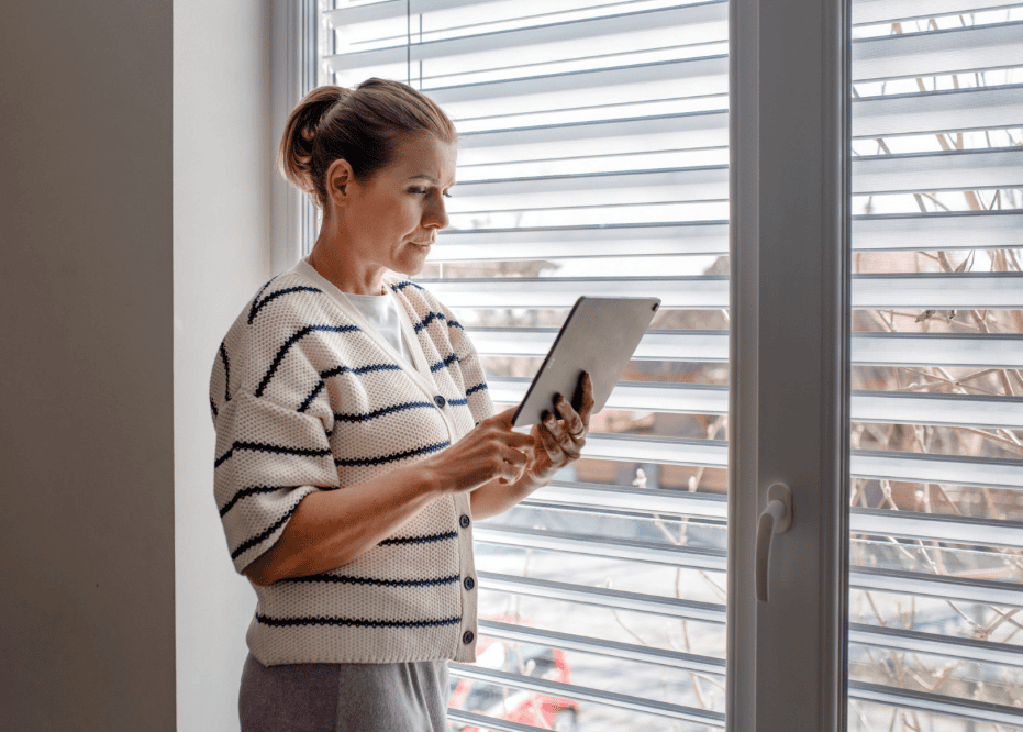 Perimenopausal woman moving more by standing while scrolling on her iPad
